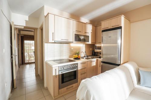 a kitchen with wooden cabinets and stainless steel appliances at Delmare Olive beach house II in Yerakiní