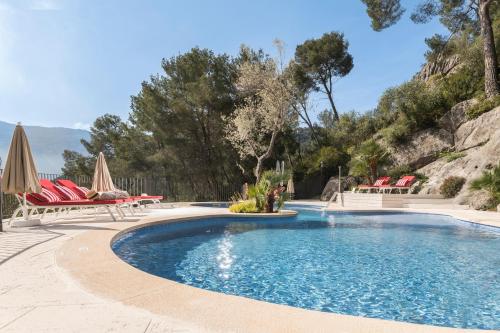 a swimming pool with chairs and umbrellas in a resort at Pure Salt Port de Sóller in Port de Soller