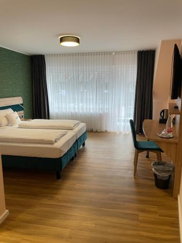 Art Hotel Eifel في هايمباخ: غرفة نوم بسرير ومكتب وكرسي