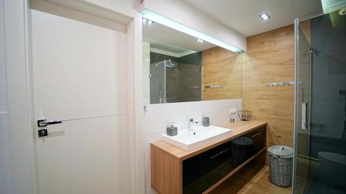 uma casa de banho com um lavatório e um chuveiro em Apartamenty Every Sky Sopocka 15-2 em Jelenia Góra