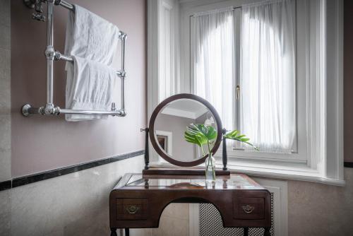 a bathroom with a sink with a mirror on it at Grand Hotel et de Milan - The Leading Hotels of the World in Milan