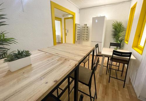 comedor con mesa de madera y sillas en AZ The Bridge Hostel - Coliving, en Zaragoza
