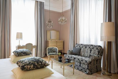 a bedroom with a bed and a couch and a chair at Grand Hotel et de Milan - The Leading Hotels of the World in Milan