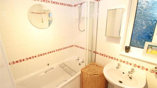 een badkamer met een bad, een wastafel en een toilet bij Rye Ground Annexe in Bishopston