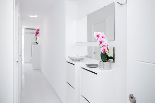 a white kitchen with flowers on a counter at La Mata Londres 2 in La Mata