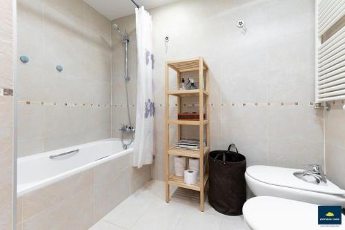 a bathroom with a tub and a toilet and a sink at Apartamento Cosy. Bonito y Acogedor Duplex in Latas