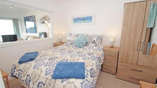 a bedroom with a bed with a blue and white comforter at Redcliffe Apartments I in Bishopston