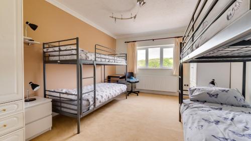 a bedroom with two bunk beds and a desk at Garrod Avenue in Dunvant