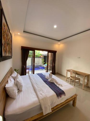 a bedroom with a large bed and a table at The Lucky Canggu in Canggu