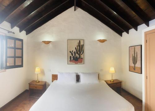 1 dormitorio con 1 cama blanca grande y 2 lámparas en Villa Estefania, en Playa Blanca