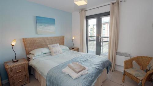 1 dormitorio con 1 cama con toallas en Fishermans Way, en Swansea