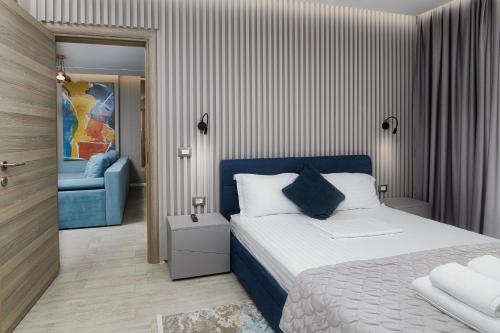 - une chambre avec un lit et une chaise bleue dans l'établissement Ely's Apartment, à Mamaia Nord – Năvodari