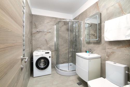 La salle de bains est pourvue d'une douche et d'un lave-linge. dans l'établissement Ely's Apartment, à Mamaia Nord – Năvodari
