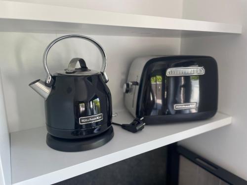 a tea kettle and a toaster sitting on a shelf at Casa 47 in Eupen