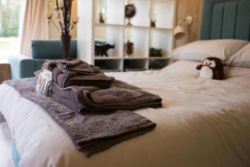 une pile de serviettes assises au-dessus d'un lit dans l'établissement Sutton Cabins, à Stowey
