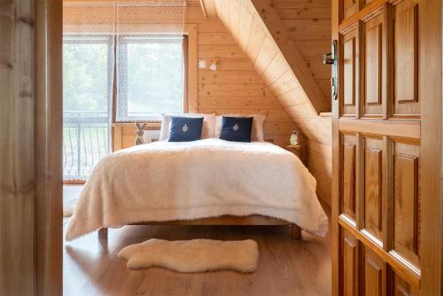 a bedroom with a bed in a wooden cabin at Białasówka in Kościelisko