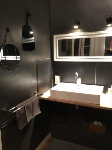 y baño con lavabo blanco y espejo. en Une nuit au second Chambre d hôtes en Lyon