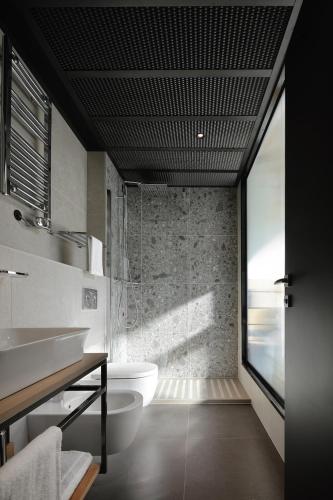 a bathroom with a sink and a toilet and a window at VERSOVERDE HOTEL Alzaia Naviglio Grande in Milan