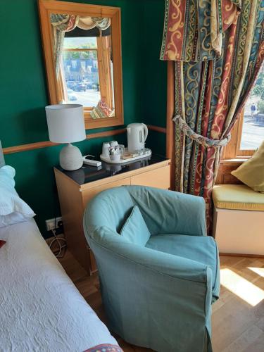 1 dormitorio con silla azul y ventana en Another Room, en Edimburgo