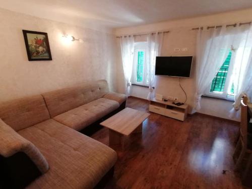 salon z kanapą i telewizorem w obiekcie Apartment in Lovran w mieście Lovran