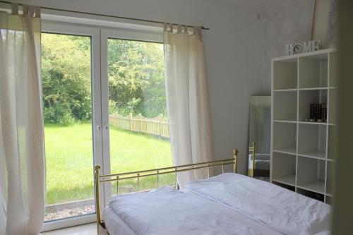 バート・ミュンダー・アム・ダイスターにあるKleines Paradies am Deister - Für euren Urlaub mit Hundのベッドルーム1室(ベッド1台、大きな窓付)