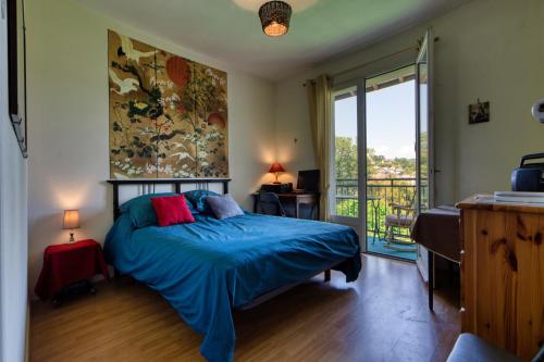 - une chambre avec un lit et une grande fenêtre dans l'établissement Appartement de charme au cœur de la Corrèze, à Brive-la-Gaillarde