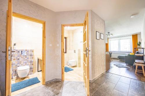 baño con puerta que da a una sala de estar en Czarna Góra Apartamenty TATRY GÓRY BIAŁKA BUKOWINA AGROTURYSTYKA, en Czarna Góra