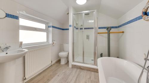 a bathroom with a shower and a toilet and a sink at Arfryn in The Mumbles