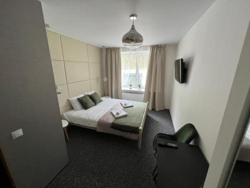 a small bedroom with a bed and a window at Hotel "Senleja" in Sigulda