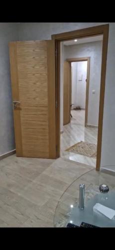 een kamer met een glazen tafel en een deur bij Résidence HALOUA in Oulad Kerroum