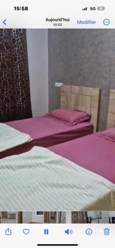 dos camas sentadas una al lado de la otra en una habitación en Résidence HALOUA, en Oulad Kerroum