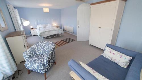 a living room with a couch and a bed at Daisy Cottage in The Mumbles