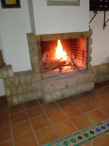 a brick fireplace with a fire in it at L'Olivera Casa Rural in Castellbisbal