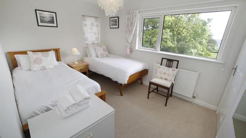 een kleine slaapkamer met 2 bedden en een raam bij Westfields in Nicholaston
