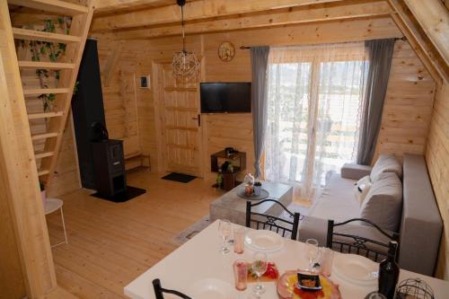 a living room with a couch and a tv in a cabin at Sweet Cottage in Mostar