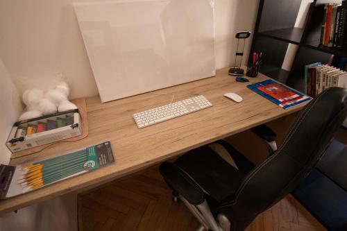 a wooden desk with a keyboard and a computer monitor at Terezin Ghetto apartman in Terezín