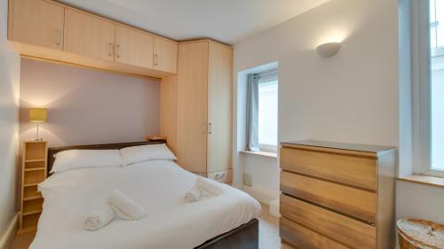 um quarto com uma grande cama branca e uma janela em Mumbles Rd Apartment em The Mumbles