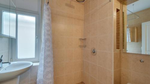 uma casa de banho com um chuveiro, um lavatório e um espelho. em Mumbles Rd Apartment em The Mumbles