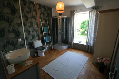 ein Bad mit einer Badewanne, einem Waschbecken und einem Fenster in der Unterkunft Ici cool une rivière in Saint-Pierre-de-Côle