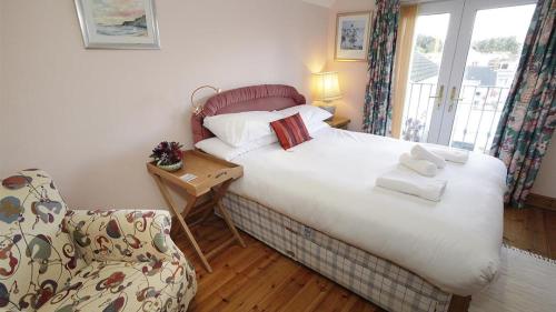 a small bedroom with a bed and a chair at Oyster Cottage in The Mumbles