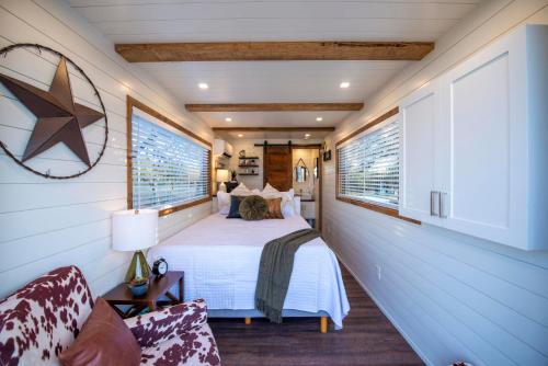 a bedroom with a bed and two windows at New The Lone Star Shipping Container in Fredericksburg