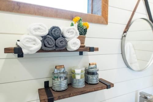 a bathroom shelf with towels and a mirror at New The Lone Star Shipping Container in Fredericksburg