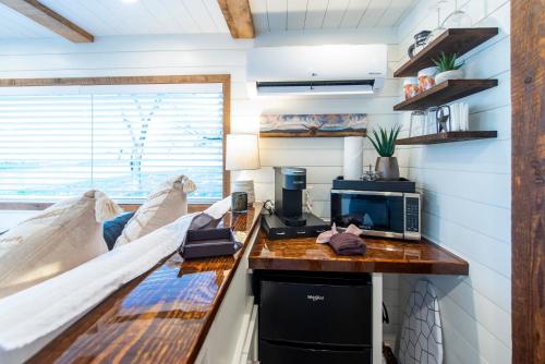 a room with a bed and a desk with a microwave at New The Lone Star Shipping Container in Fredericksburg