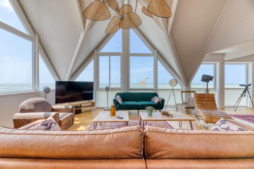 a living room with a couch and a tv at Le poséidon, gîte EXCEPTIONNEL face à la mer avec spa, terrasse, 4 chambres UN VRAI COUP DE COEUR in Fécamp