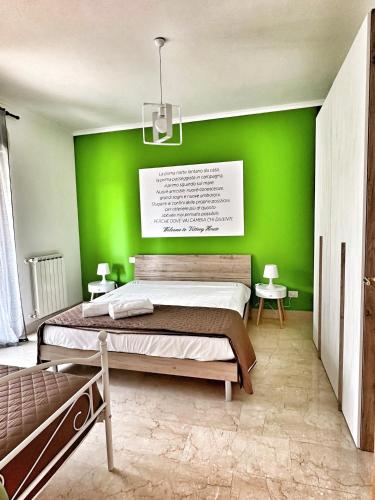 a green bedroom with a bed and a green wall at Vittory house in Lido di Ostia