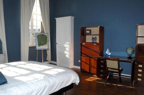1 dormitorio con cama, escritorio y ventana en Petit château à la campagne., en Beloeil