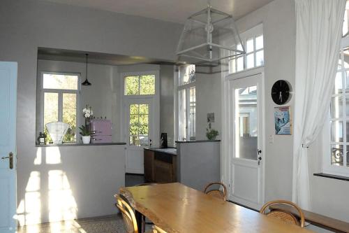 a dining room with a table and a kitchen at Petit château à la campagne. in Beloeil