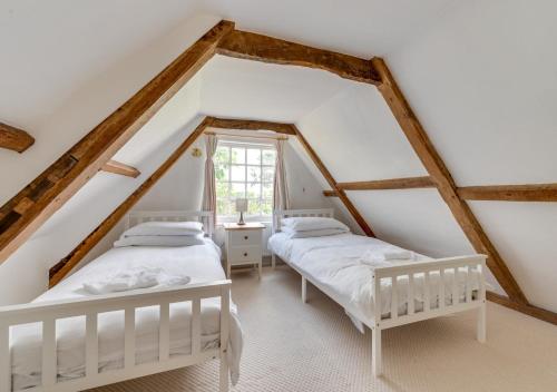 two beds in a attic bedroom with wooden beams at 2 The Old Vicarage in Wangford