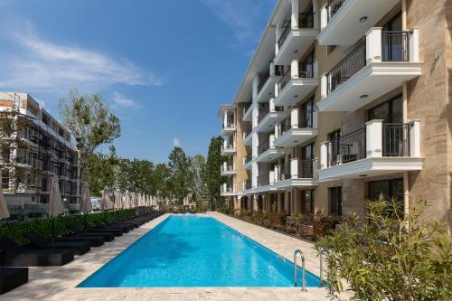an apartment complex with a swimming pool in front of a building at Emilia Romana Park in Sunny Beach