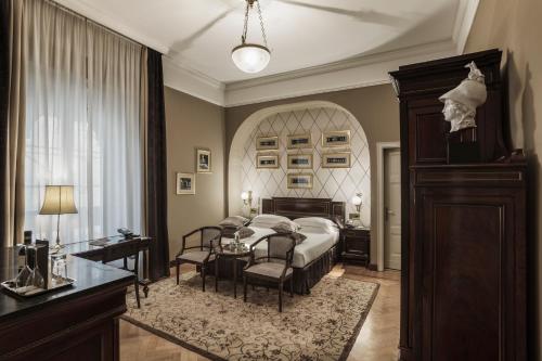 a bedroom with a bed and a table and chairs at Grand Hotel et de Milan - The Leading Hotels of the World in Milan